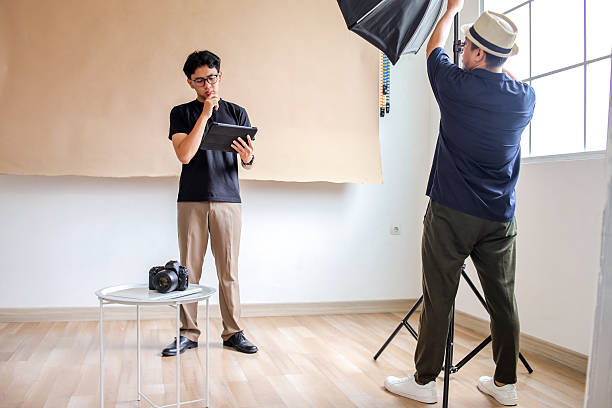 istock Photography Man Setup Studio for Photo Session With Attention To Lighting And Direction 2236217428
