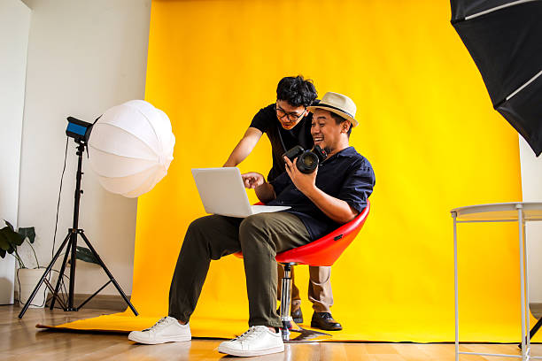 istock Photographer And Model Share A laugh While Reviewing Photos On A Laptop During A Fun Studio Session 2236217554