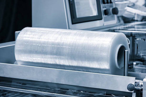 istock Automatic polyethylene plastic bag production machine with lighting effect. Close-up of the roller of the plastic bag production machine in the light blue scene. product packaging concept 2236218309