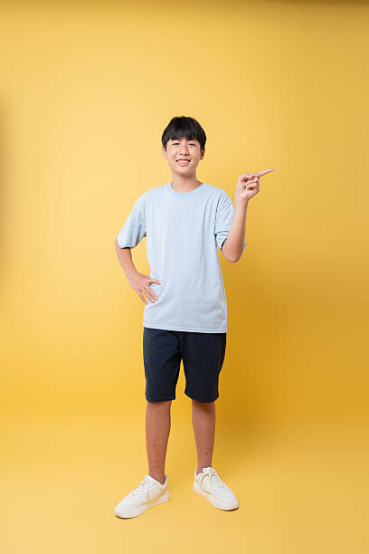 istock Youthful Individual on Yellow Backdrop: A young person gestures with a cheerful expression 2236218370