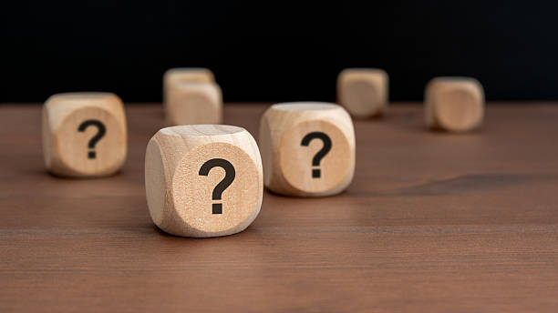istock three wooden blocks with question marks over a black background with copy space 2236219468