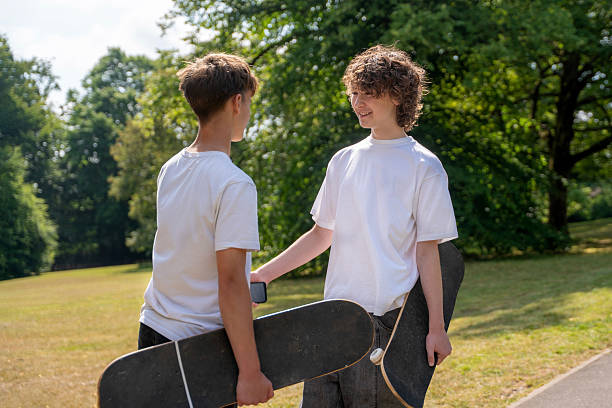 istock Two boys share a moment with skateboards in a sunny park during late afternoon 2236223775