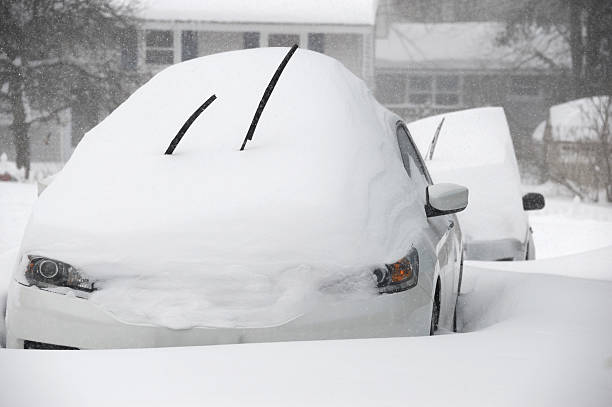 istock close up on snow covered car on the driveway in blizzard 2236224529