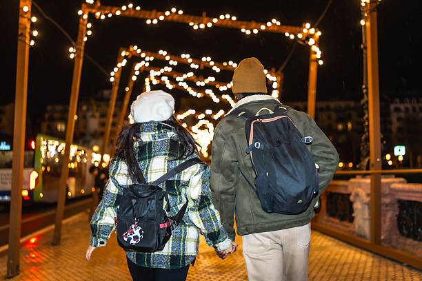 istock Tourists walking through christmas market at night 2236225407