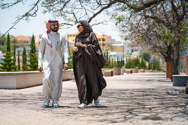 istock Arabic Couple Walking in Abha Park with Jacaranda Trees 2236226075