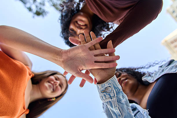 istock Young women joining hands in a symbol of unity and teamwork 2236227660