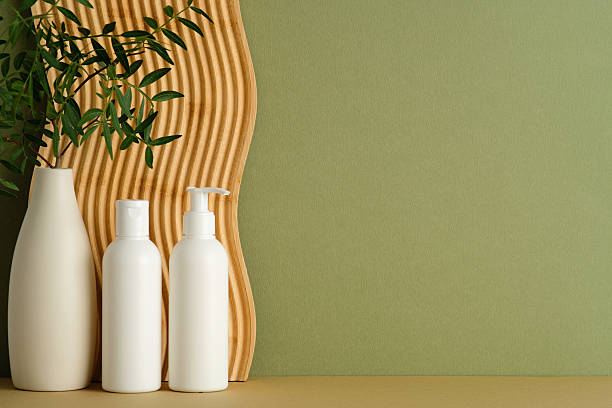 istock Two white bottles and vase with greenery on beige surface, wavy panel, olive green background, natural skincare style. 2236227857