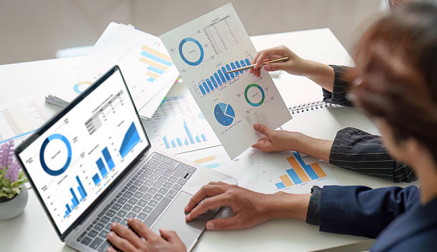 istock Collaborative Analysis. Professionals discussing financial data with reports and laptop. 2236230157
