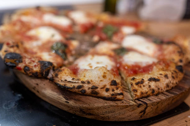 istock Rustic Wood-Fired Pizza Featuring Melted Cheese and Tomatoes on a Wooden Board 2236231955
