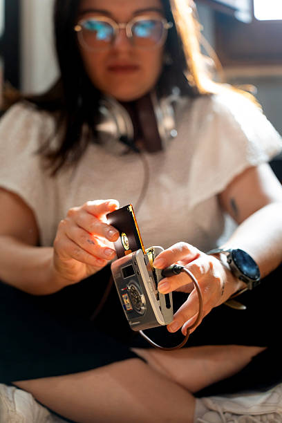 istock Woman inserting minidisc into retro digital camera for playback 2236233556