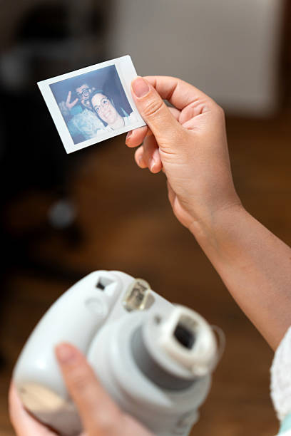 istock Holding instant camera print with smiling couple selfie 2236233570