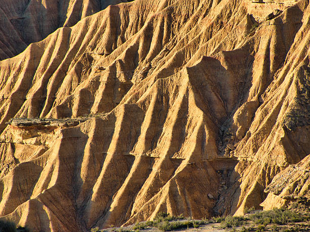 Golden hour light on detailed badlands rock formation - Striking abstract patterns of a unique arid landscape texture, perfect for travel, nature, and geology themes.