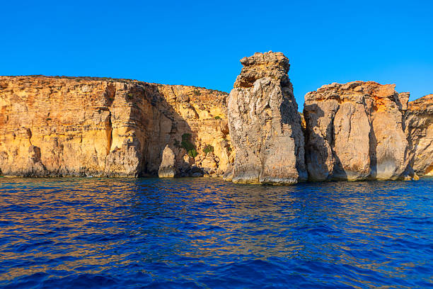 Discover breathtaking Blue Lagoon, vibrant turquoise waters meet dramatic limestone cliffs under blue sky. Iconic Mediterranean paradise invites you to swim and explore its unparalleled natural beauty