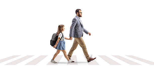 istock Father and daughter holding hands and walking at a zebra crossing 2236237383