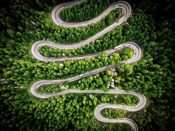 istock Drone view of winding forest road in Romania 2236237542