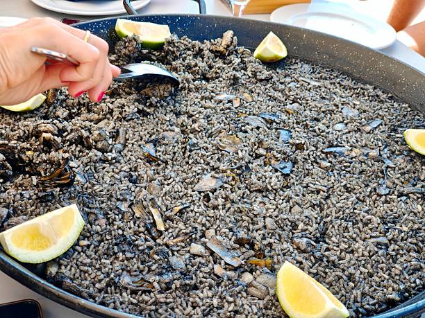 istock Spanish Alicante-style rice cooked separately from the fish; paella with black rice. 2236242649