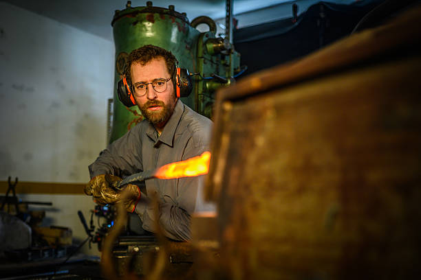 istock Mid Adult Blacksmith Working with Heated Metal in Forge 2236243586