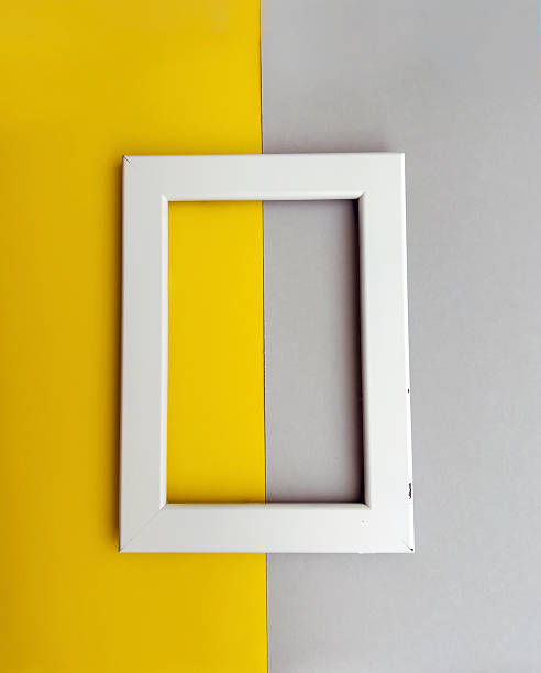 istock White wooden frame on yellow and gray background with copy space for text 2236245009