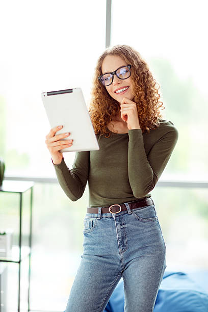 istock Young female entrepreneur using tablet in a modern interior setting, radiating charm and confidence at her workspace 2236245276