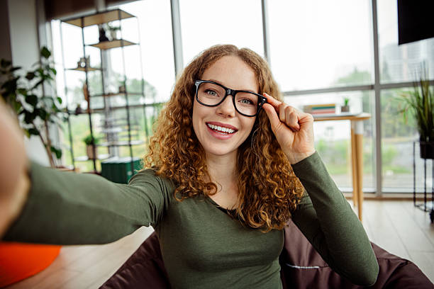 istock Charming young woman with glasses smiling in a modern interior space, enjoying a comfortable moment of leisure 2236245461
