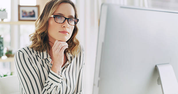 istock Woman, freelancer and reading on computer at house for research, editor feedback and proofreading. Thinking, journalist and PC to review article, fact check and planning story for project publication 2236247152
