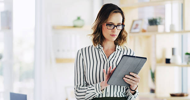 istock Business woman, office and tablet for research with policy development, reading email or feedback. Technology, notes and consultant in company for project review, compliance and check schedule online 2236247192
