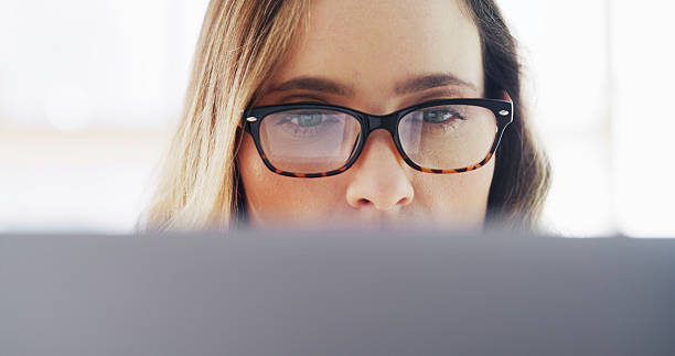 istock Woman, glasses and reading on computer at house for research, editor feedback and proofreading. Female person, journalist and pc to review article, fact check and story report for project publication 2236247297