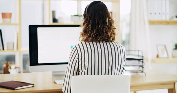 istock Back, computer screen and woman in home office with headset, telecoms or research in remote work. Digital, email and virtual assistant in living room with tech, coordination or schedule in online job 2236247309