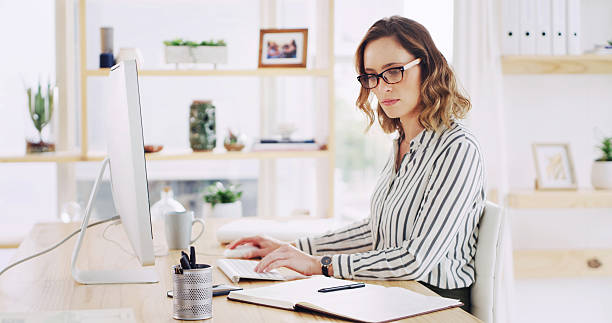istock Computer, reading notebook and business woman in office for email, coverage and insurance policy. Desktop, research and serious broker at workplace for risk management, review notes and project 2236247338
