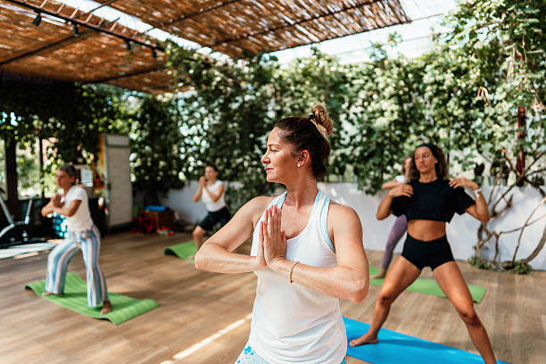 istock Group of women practicing yoga in a bright studio 2236248910