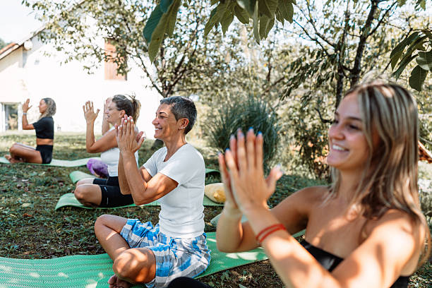 istock Women meditating in outdoor yoga class with instructor 2236249003