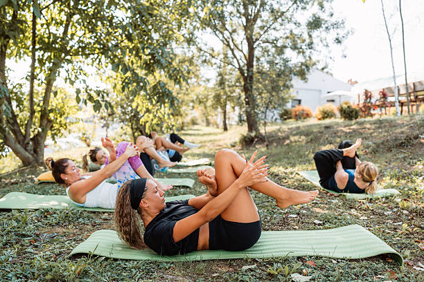 istock Women group practicing yoga outdoors on mats 2236249079
