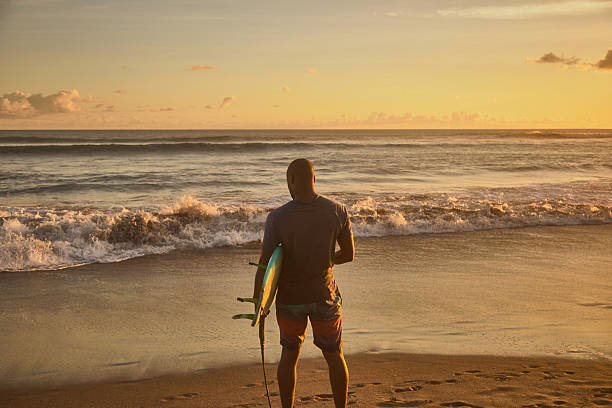 istock Surfers preparing for a session at sunset on a tranquil beach 2236251779
