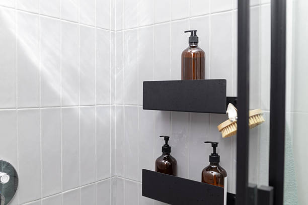 istock Bathroom shower corner with black shelf, amber bottles, and brush 2236253604