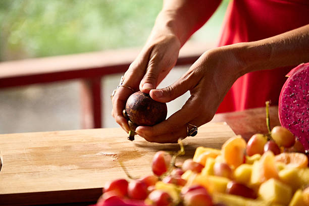istock Close-up of hands preparing tropical fruit on a wooden surface 2236257612