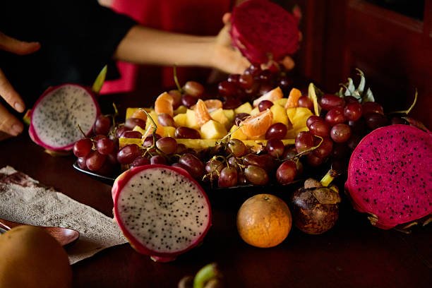Assorted fresh fruits including dragonfruit and grapes arranged on a table