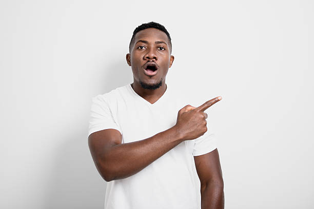 istock Black men wearing white shirt in studio shot on white background pointing 2236257764