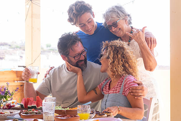 istock Happy Multi generation family share brunch together in a sunny day. Festive table with a colorful mix of vegetables and fruit for a healthy eating. 2236258318