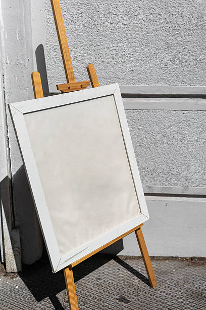 istock A light blank in a frame standing on a wooden easel on the street. Copy space, background for designer. vertical photo 2236260352