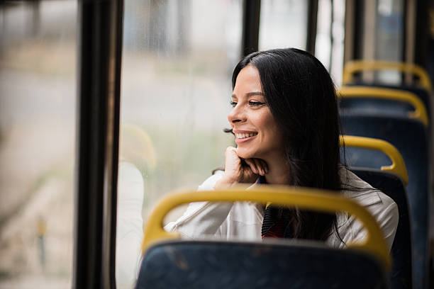 istock Happy young woman on bus by window 2236260701