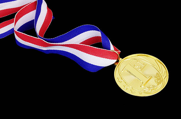 Human hand holding gold medals.