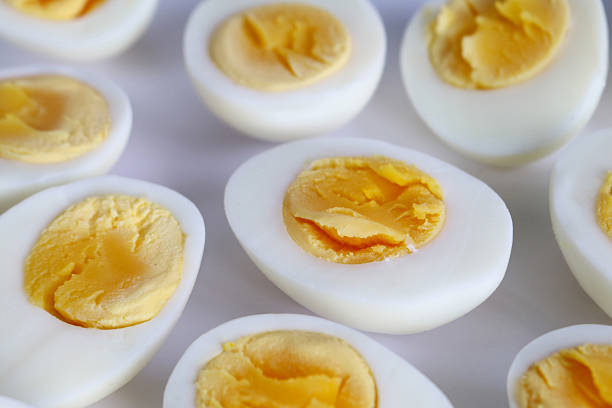 istock Full frame image of group of hard-boiled chicken egg halves isolated on white background, studio shot, healthy eating poster wallpaper background design, elevated view 2236262282