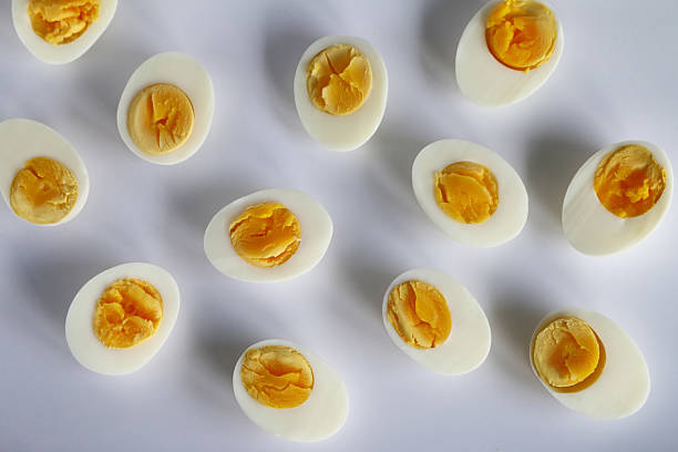 Stock photo showing elevated view of hard-boiled chicken egg halves isolated on a white background.