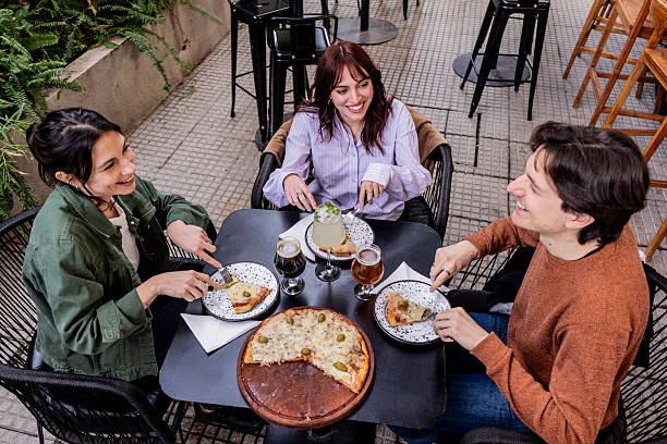 istock Friends drinking and eating pizza in a restaurant 2236264250