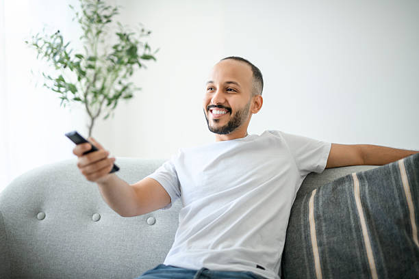 istock young islamic arab man relaxing on sofa at home watching tv 2236266615