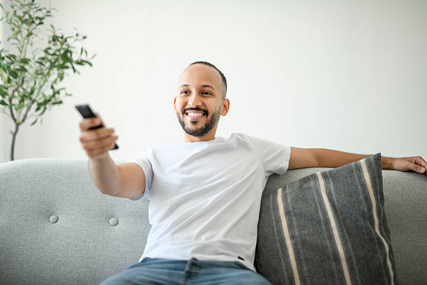istock young islamic arab man relaxing on sofa at home watching tv 2236266617