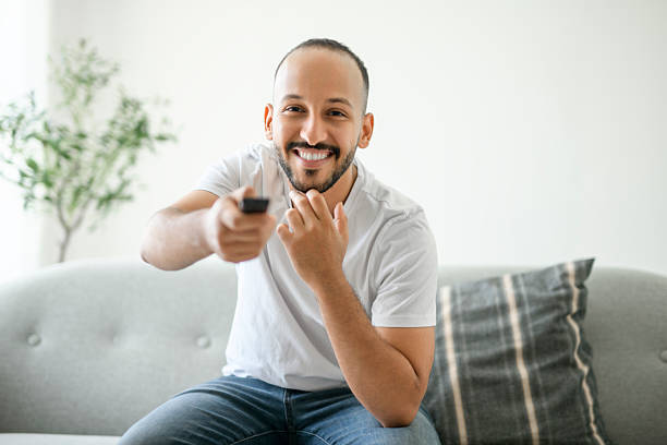 istock young islamic arab man relaxing on sofa at home watching tv 2236266621