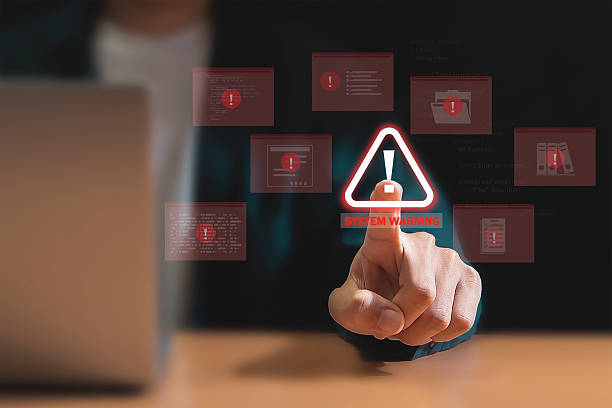 istock Programmer uses laptop with warning triangle sign to alert for errors and maintenance concepts. 2236267527
