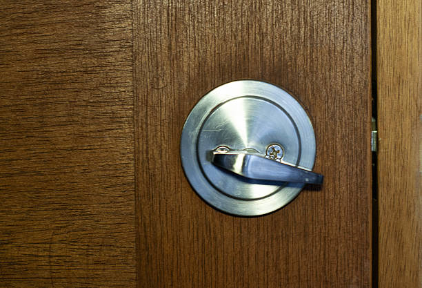 Closeup of a metal lock on a wooden door, highlighting details of the security mechanism and texture of the wood. Ideal for concepts of safety, privacy, protection, architecture, and home design.