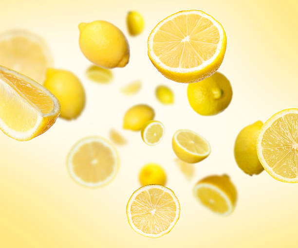 istock Fresh ripe lemons swirling in air against yellow gradient background 2236275922